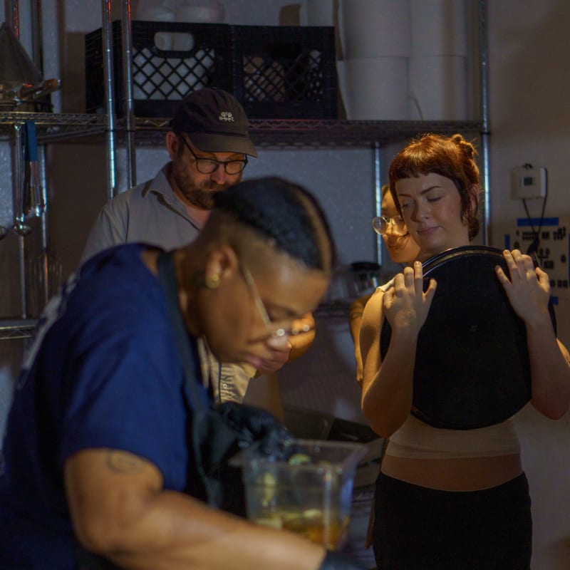 Chef Jay plating food with guests nearby