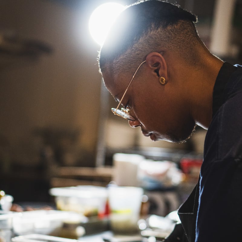 Chef Jay finishing a dish with black gloves
